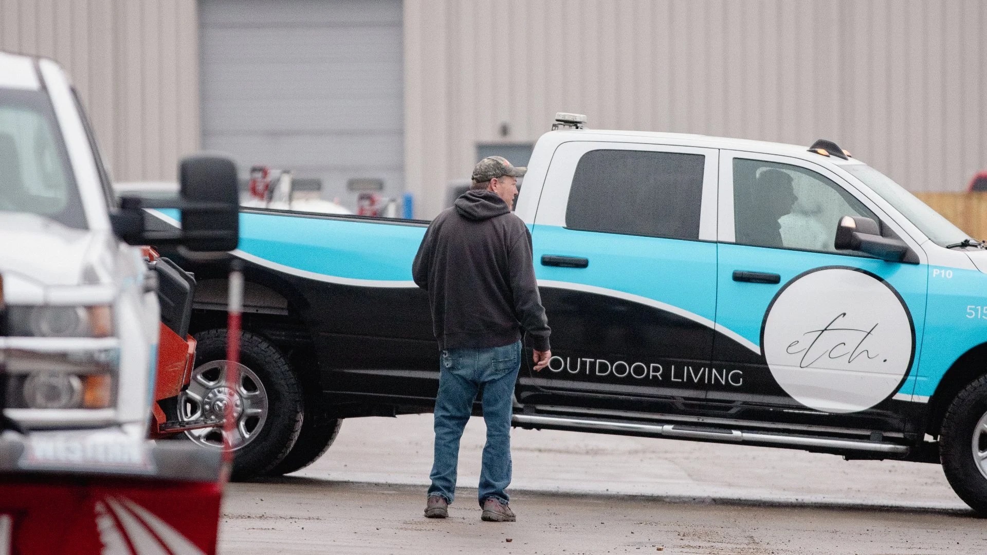 ETCH Outdoor Living Worker standing next to truck in gear in Ankeny, IA.