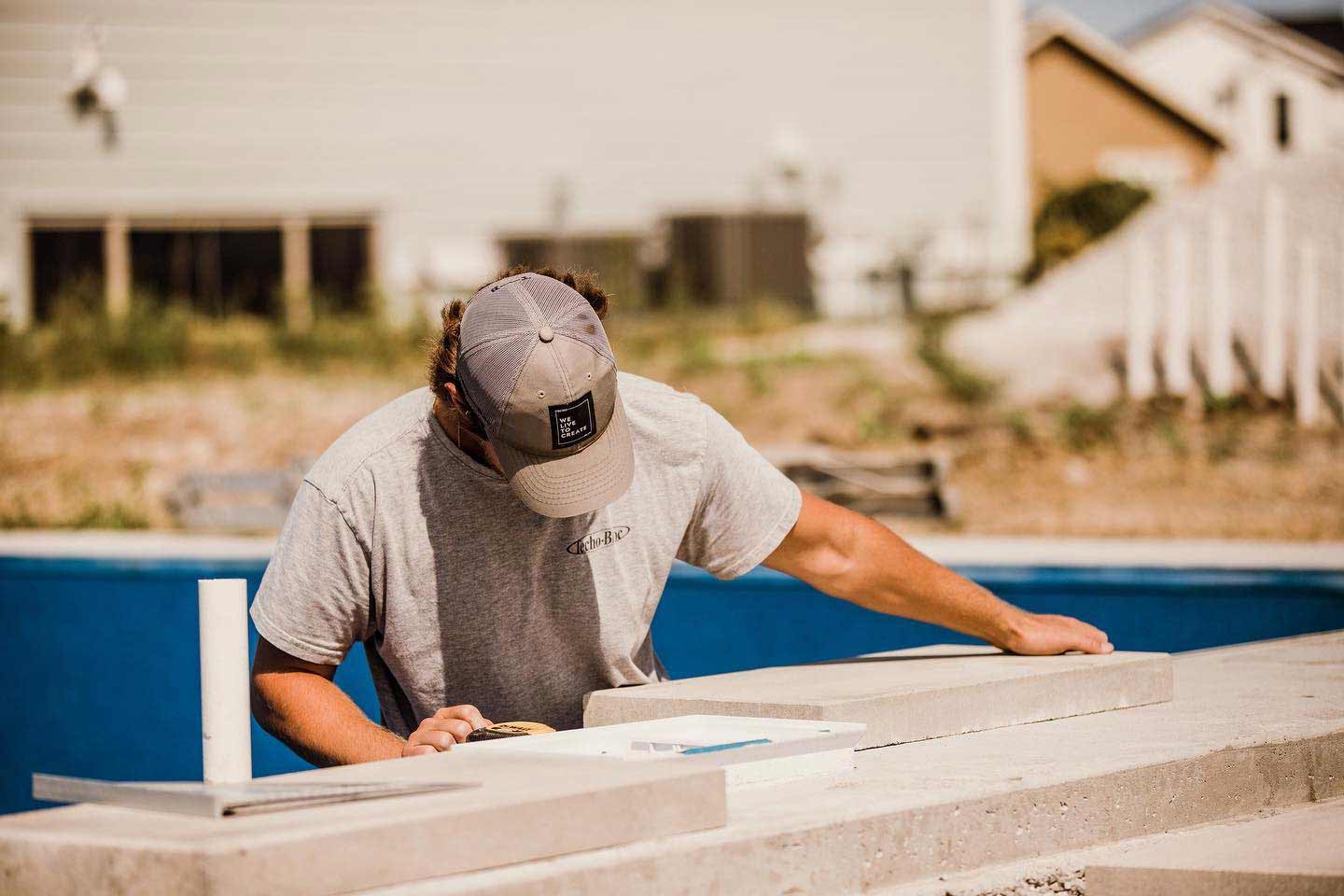 ETCH Outdoor Living technician measuring hardscape materials in Ankeny, IA.