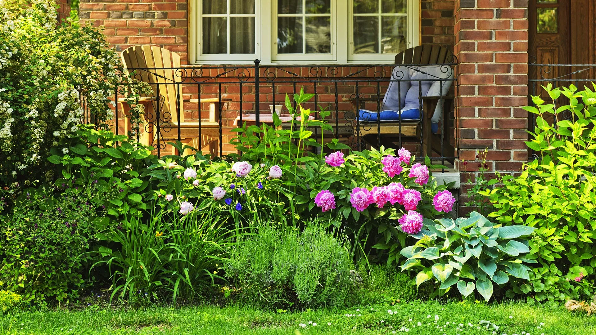 A front patio surrounded by flowering landscape beds in West Des Moines, IA. 