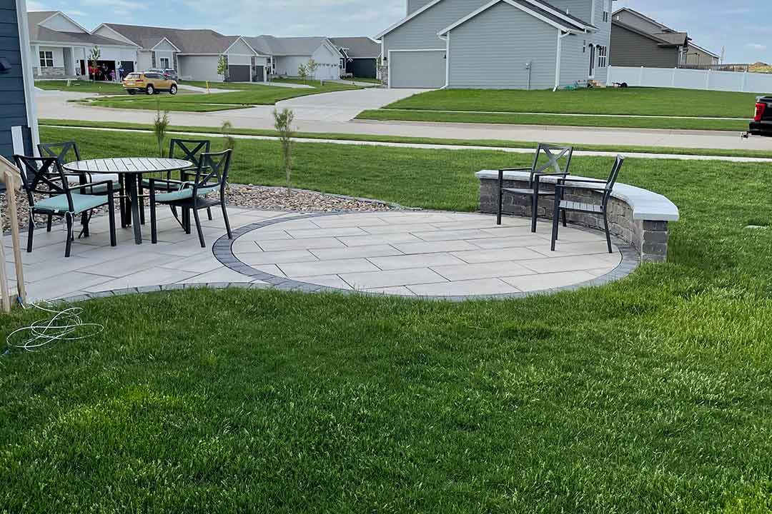 Custom patio with seating wall and rock mulch in Ankeny, IA.