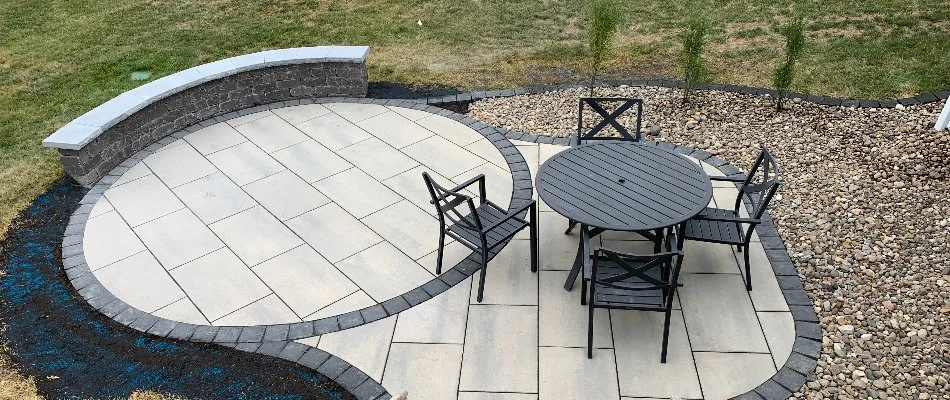 Paver patio in Ankeny, IA, with seating wall and furniture.