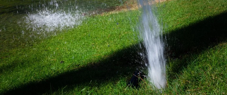 Water bursting on a lawn in Ankeny, IA, from an irrigation pipe.
