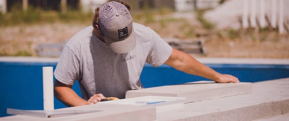 Worker adjusting a concrete block along a pool in Ankeny, IA.