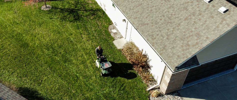 Aerial view of Ankeny professional fertilizing lawn with spreader in Ankeny, IA.