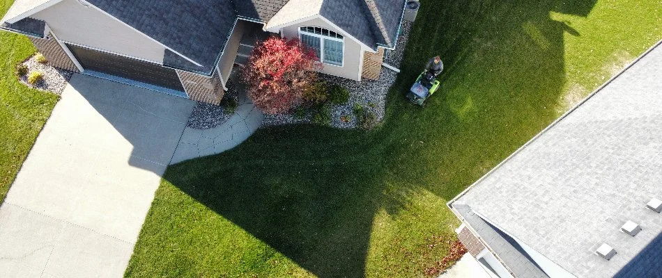 Aerial view of Ankeny professional fertilizing lawn with spreader in Ankeny, IA.