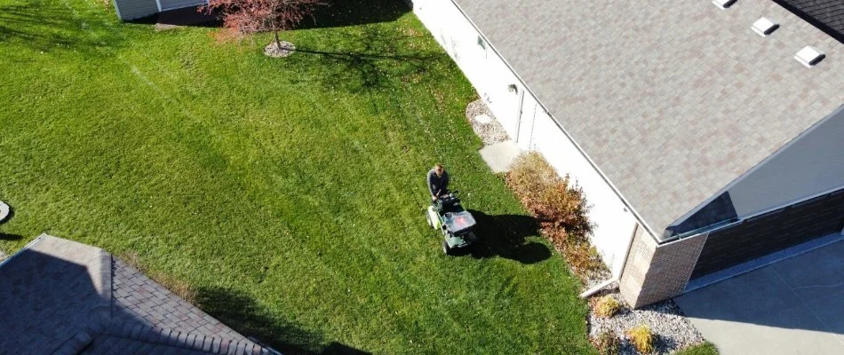 Aerial view of worker applying treatment on a lawn in Coralville, IA.
