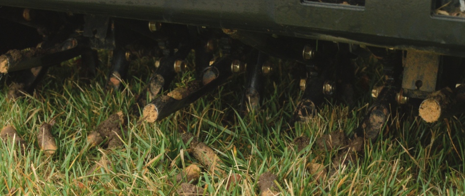 Core aerator machine with plugs over lawn in Bondurant, IA.