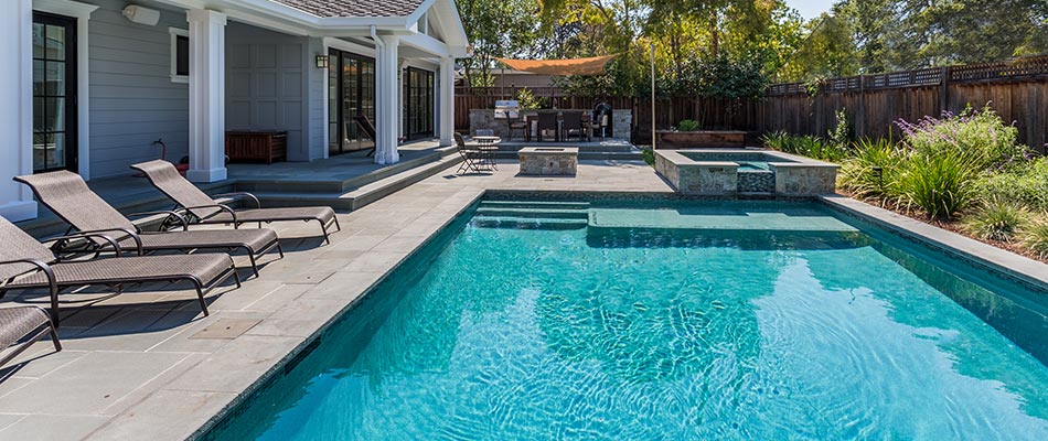 Custom patio around a beautiful, blue swimming pool in Elkhart, IA.