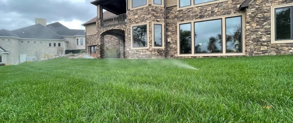 Sprinkler system spraying water on a lawn in Coralville, IA.