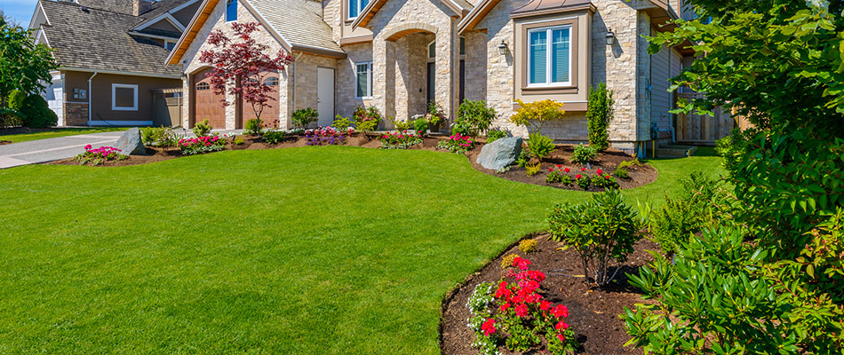A neat green lawn due to regular lawn and landscape services in front of a home in Bondurant, IA.
