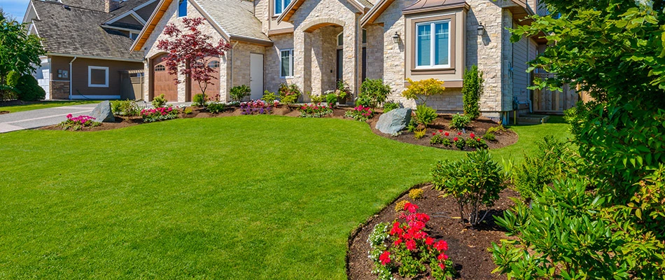 A neat green lawn due to regular lawn and landscape services in front of a home in Bondurant, IA. 