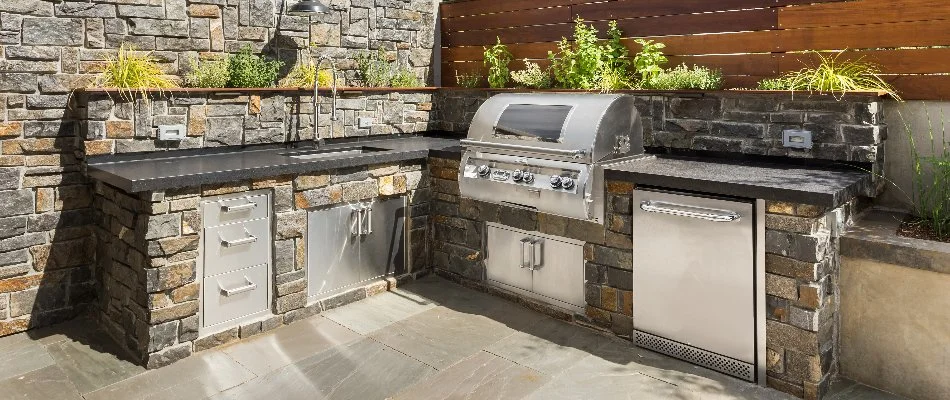 Outdoor kitchen with grill and sink on a property in Ankeny, IA.
